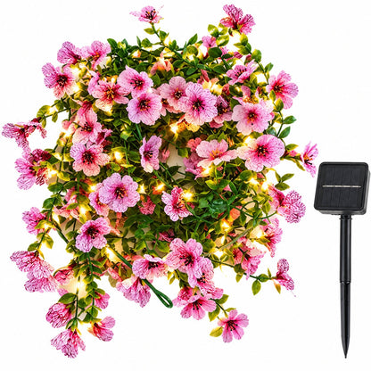 Artificial violet flower solar fairy lights with pink blossoms and ground stake solar panel on white background